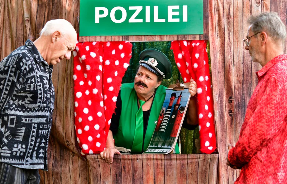 Der Polizist zeigt den zwei Freunden ein Bild